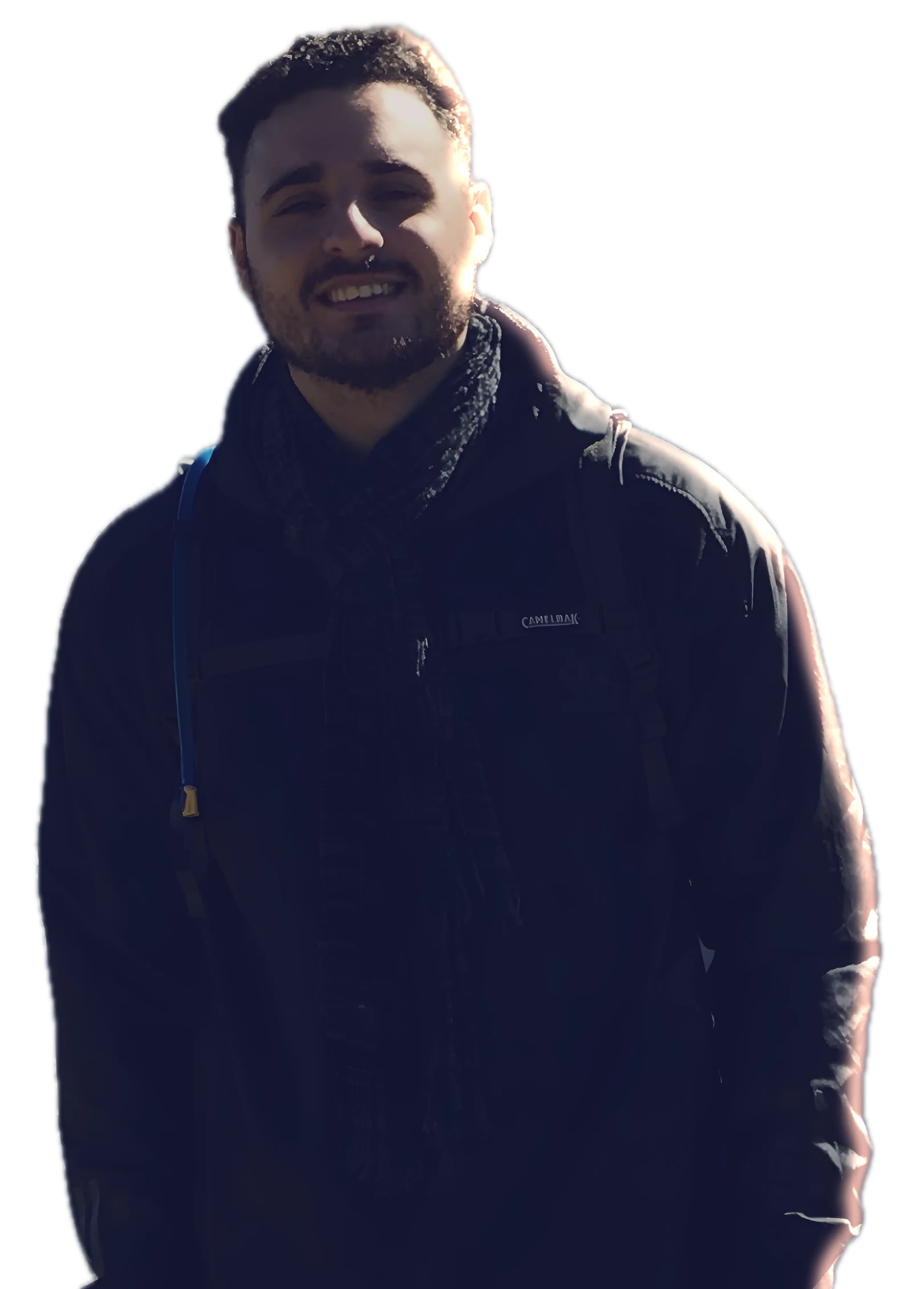 Dimitri smiling, standing on a mountain summit at night